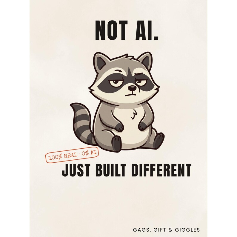 May include: A graphic print featuring a cartoon raccoon with a skeptical expression. The text reads NOT AI. JUST BUILT DIFFERENT. A small red stamp says 100% REAL 0% AI. The bottom right corner includes the text GAGS, GIFT & GIGGLES on a light background.