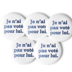 Könnte beinhalten: Fünf runde, weiße Ansteckbuttons, die in einer Gruppe angeordnet sind. Jeder Button trägt den Text "Je n'ai pas voté pour lui." in einer fetten, blauen serifenlosen Schrift. Die Buttons haben eine glatte, glänzende Oberfläche und ein rundes Design.