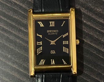 Reloj de pulsera Seiko Slim de cuarzo vintage para caballero, con caja dorada y esfera negra - ENVÍO GRATIS