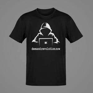 May include: Black t-shirt featuring a white graphic of a hooded figure using a laptop with a skull and crossbones icon. The text "demandrevolution.now" is printed below the graphic.