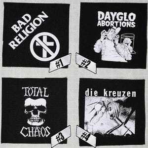 May include: Four black fabric patches with white text and graphics. The patches feature the band names "Bad Religion", "Dayglo Abortions", "Total Chaos", and "Die Kreuzen".