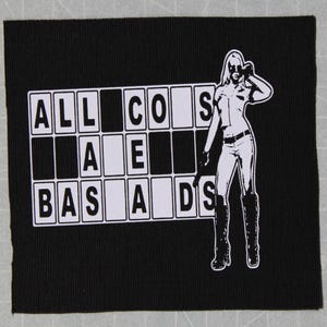 May include: Black and white patch with a woman in a white outfit and sunglasses standing in front of a grid with the words "ALL COS BAS AIDS" written in white.