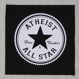 May include: Black and white patch with a white star and the text "Atheist Free Thinker All Star" in a circle.