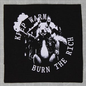 May include: Black and white patch with a squirrel wearing a leather jacket and holding a sign that says "Keep Warm Burn The Rich".