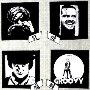 May include: Four black and white square patches featuring iconic movie imagery. Includes images of a character with a helmet, a man smiling, a character with a hat, and a figure with the word "GROOVY". Each patch has a numbered tag.