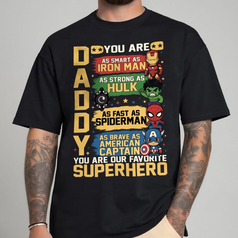 May include: Black t-shirt with a colorful graphic featuring the word "DADDY" and the phrase "YOU ARE OUR FAVORITE SUPERHERO." The design includes illustrations of Iron Man, Hulk, Spiderman, and Captain America.