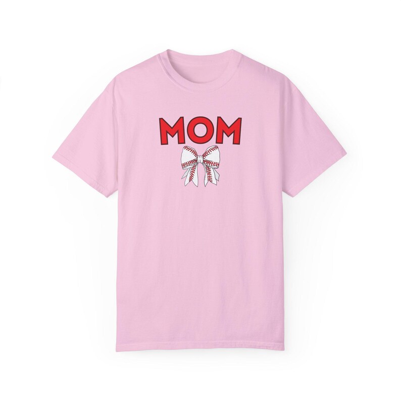 Peut inclure: T-shirt rose avec le mot "MOM" en lettres rouges et un n&oelig;ud blanc sur le th&egrave;me du baseball.