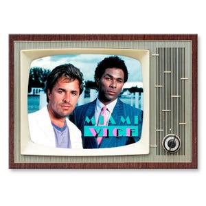 May include: A vintage television screen showing a scene from the TV show "Miami Vice". Two men, one in a white shirt and the other in a blue pinstripe suit, are standing in front of a blue and teal background with the show's title in pink and turquoise letters.