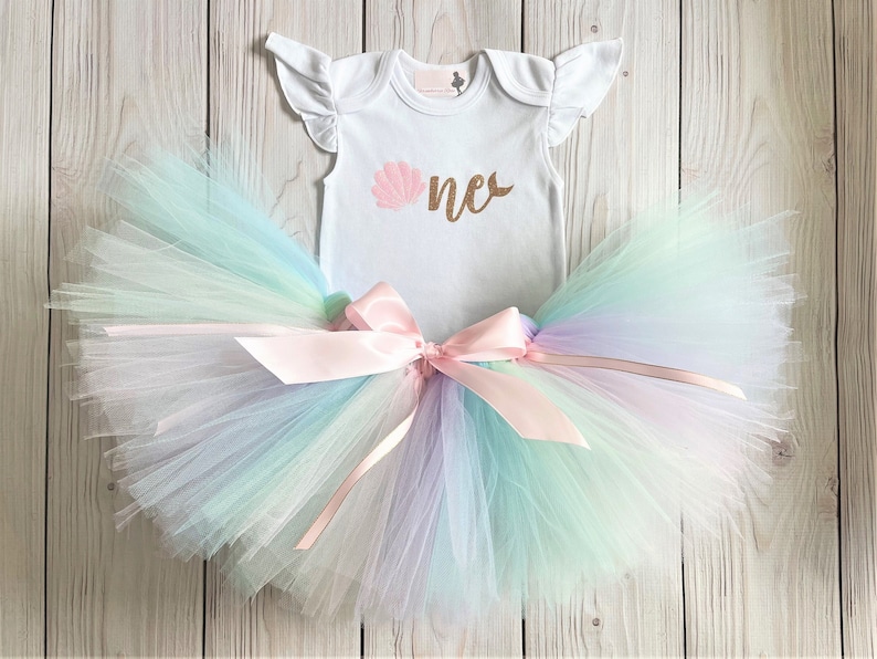 The perfect Mermaid Shellabrate birthday outfit for your little princess! Can be made to match a birthday party theme! This listing includes choice of 1 handmade Tutu on stretch elastic, 1 bodysuit and 1 hair bow on a elastic headband.