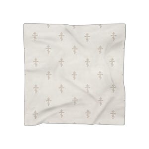 May include: A square scarf in a light off-white color featuring a repeating pattern of small, light beige Eastern Orthodox crosses. The fabric has a soft, slightly wrinkled texture with a subtle diamond-shaped quilted stitching pattern throughout.