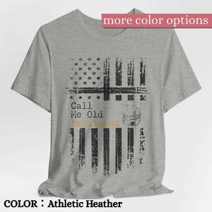 May include: An athletic heather gray short-sleeve t-shirt featuring a distressed black graphic of an American flag. The design includes the text "Call Me Old Fashioned" in black and gold lettering, accompanied by a graphic of a rocks glass.