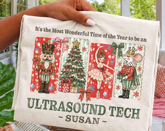 Puede incluir: Una camiseta color marfil con un gráfico navideño de un cascanueces, un árbol decorado, una bailarina y un ratón con uniforme. El texto dice: It's the Most Wonderful Time of the Year to be an ULTRASOUND TECH ~ SUSAN ~.