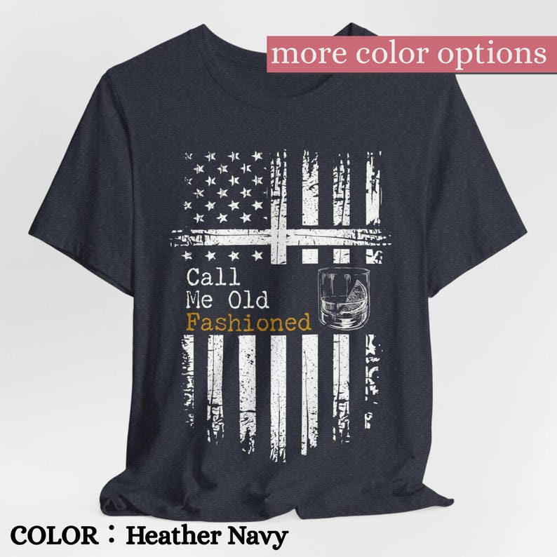 May include: A heather navy short-sleeve t-shirt featuring a distressed white graphic of the American flag. The design includes a glass of whiskey and the text Call Me Old Fashioned in white and gold lettering centered on the front chest.