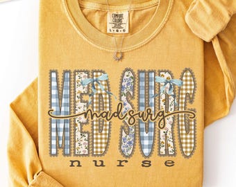 Puede incluir: Una camiseta de manga larga color amarillo mostaza con el texto MED SURG en letras grandes con un patrón de cuadros vichy azules, flores y cuadros beige. La palabra nurse está impresa debajo en letras más pequeñas, con lazos azul claro.