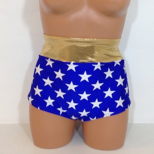 Puede incluir: Pantalones cortos azules y blancos de cintura alta con una banda dorada metálica y un patrón de estrellas.