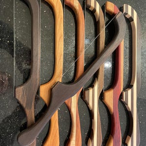 Puede incluir: Cinco cuchillos de queso de madera con diferentes patrones de veta de madera. Los cuchillos tienen un bucle de alambre para cortar queso.