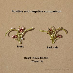 Puede incluir: Un broche floral dorado con p&eacute;talos de esmalte rosa y rojo y peque&ntilde;as perlas blancas. La imagen muestra el frente y el reverso del broche con el texto Positive and negative comparison, Height 4.06cm/width 6.35cm, Weight 15g.