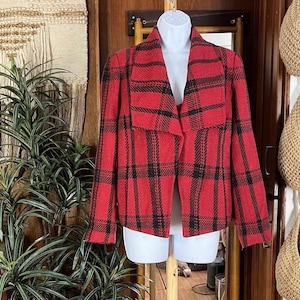 May include: A red and black plaid jacket with a shawl collar. The jacket is displayed on a white mannequin. The jacket has a classic plaid pattern in red and black. The jacket is a medium weight.
