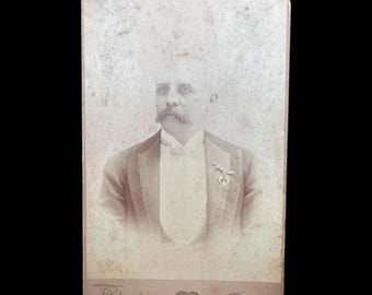 Fotografía en formato tarjeta de gabinete de un hombre identificado con un pin de los Shriners de Brooklyn, Nueva York.