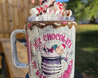 Könnte beinhalten: Weißer Keramikbecher mit einem Heißschokoladen-Design, garniert mit Schlagsahne, Marshmallows und Zuckerstangen. Der Becher trägt den Text "Hot Chocolate to Warm Your Soul" und eine Grafik einer Heißschokoladen-Tasse.