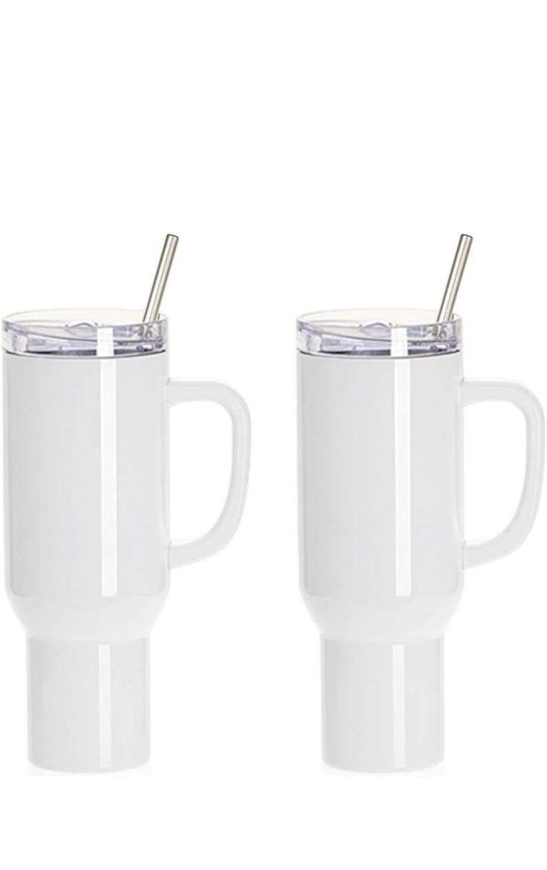 May include: Two white insulated travel mugs with handles and clear lids. Each mug has a silver-colored straw inserted. The mugs are designed to keep beverages hot or cold. Perfect for coffee, tea, or other drinks.