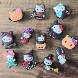 May include: A selection of Halloween-themed shoe charms featuring a popular cartoon character in various costumes. The charms include designs such as a pumpkin, a witch, a bat, and a character dressed as a horror movie villain. The charms are colourful and made of rubber.