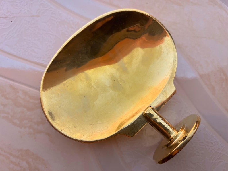 Handcrafted brass soap dish on marble background, wall mounted bathroom accessory.