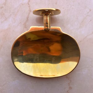 Handcrafted brass soap dish on marble background, wall mounted bathroom accessory.
