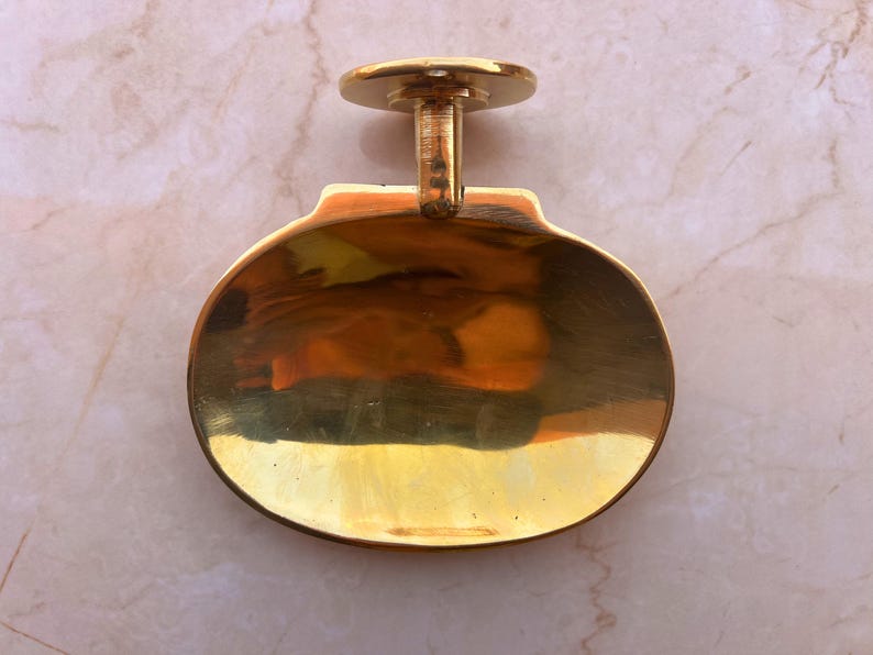 Handcrafted brass soap dish on marble background, wall mounted bathroom accessory.
