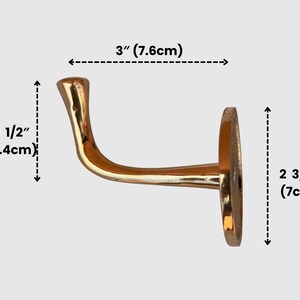 Brass wall hook with measurement overlay.