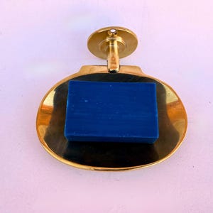 Wall mounted brass soap dish with blue bar soap, handmade bathroom accessory.