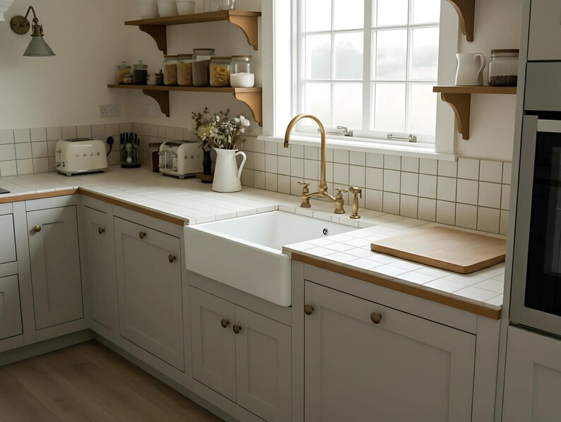 Solid brass bridge faucet in farmhouse kitchen with apron sink, wood details, and white tile backsplash for a vintage look.