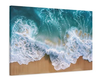 May include: An aerial view of a sandy beach with turquoise blue ocean water crashing onto the shore. White foamy waves are breaking and creating a pattern on the sand.