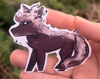 May include: A sticker of a cartoon wolf with a dark brown body, white fur, and a black nose. The wolf has a crown on its head and is standing on all fours.