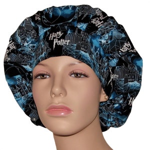 May include: A black and blue surgical scrub hat with a white print of the Hogwarts castle and the words "Harry Potter".
