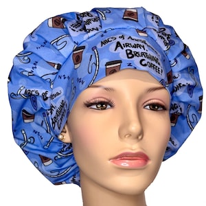 May include: Blue surgical scrub hat with a pattern of coffee cups and the text "ABC's of Anesthesia: Airway, Breathing, Coffee!"