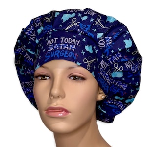 May include: A navy blue surgical scrub cap with a repeating pattern of white text, blue medical symbols, and light blue cloud shapes. The cap features the text "NOT TODAY SATAN SURGEON" in white and blue.