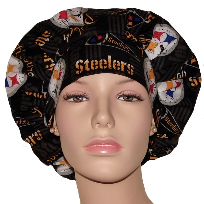 May include: Black and yellow surgical scrub hat with a Pittsburgh Steelers logo and the word "Steelers" repeated throughout the design.