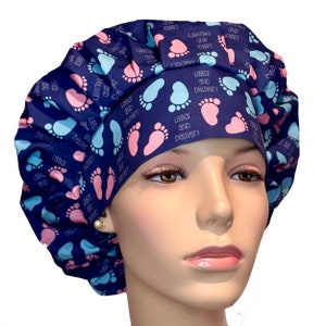 May include: Blue surgical scrub hat with a pattern of pink and blue footprints and the text "Labor and Delivery".