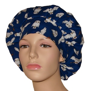 May include: A dark blue bouffant scrub cap featuring a repeating pattern of white owls carrying letters. The owls are depicted in various poses against a dark blue background. The cap is designed to cover the hair.