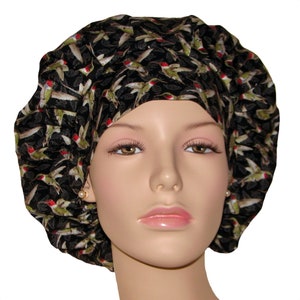 May include: A black scrub cap with a pattern of colorful hummingbirds. The cap is made of a soft, comfortable fabric and is designed to be worn by medical professionals.