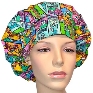 May include: A colorful surgical scrub hat with a comic book style print featuring various medical specialties, including 'Neuro', 'Spine', 'Ortho', 'Plastics', 'Gen Surg', and 'ENT'.