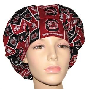 May include: A red and black patterned surgical scrub hat with the University of South Carolina logo and mascot. The hat is made of a soft, comfortable fabric and is perfect for nurses, doctors, and other medical professionals.