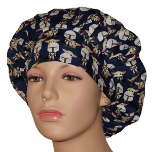 May include: A blue scrub hat with a repeating pattern of a cartoon character wearing a helmet. The character is green with large eyes and a small mouth. The hat is made of a soft, comfortable fabric and is perfect for healthcare professionals.