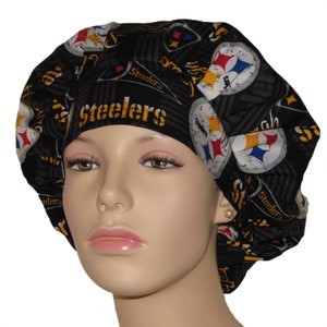May include: Black scrub hat with a Pittsburgh Steelers logo and the word "Steelers" repeated throughout the fabric.