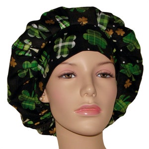 May include: Black scrub hat with a green and gold shamrock print. The hat is made of a soft, comfortable fabric and has a tie closure.