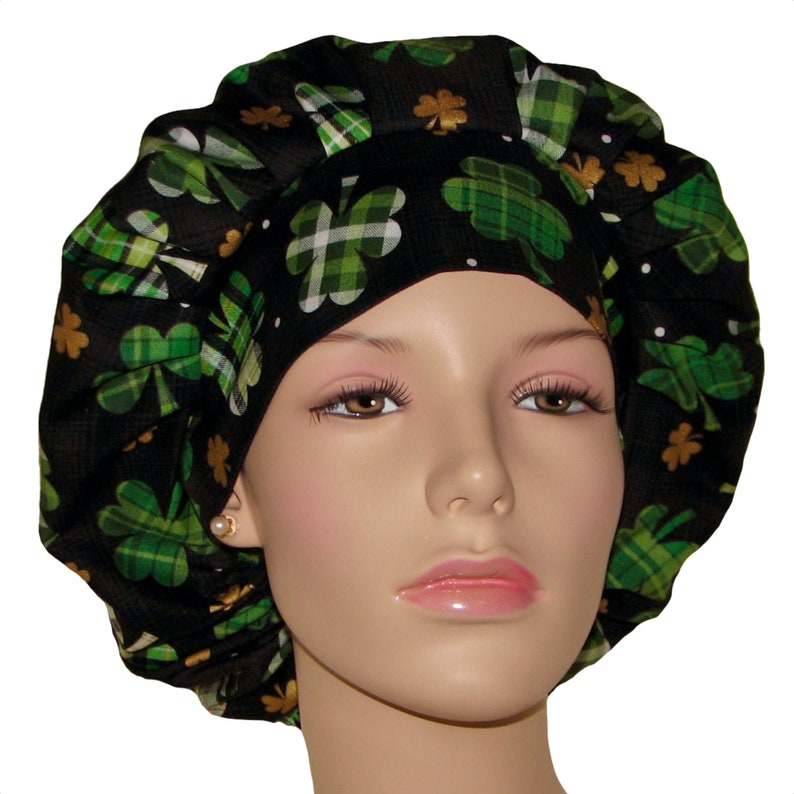 May include: Black scrub hat with a green and gold shamrock print. The hat is made of a soft, comfortable fabric and has a tie closure.