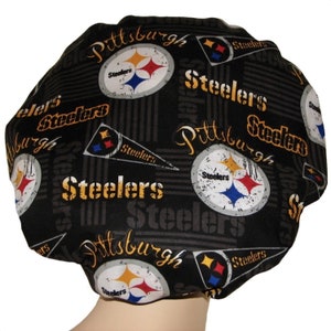 May include: Black shower cap with a repeated pattern of the Pittsburgh Steelers logo, the team name, and the city name. The logo features a black and yellow star with a blue and white football.