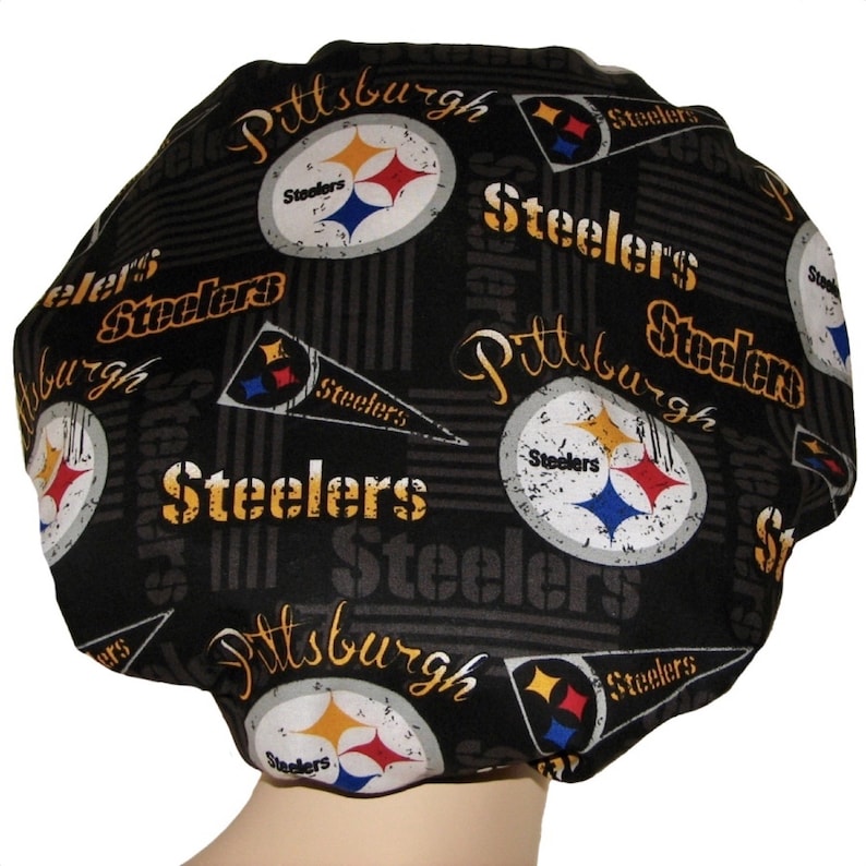 May include: Black shower cap with a repeated pattern of the Pittsburgh Steelers logo, the team name, and the city name. The logo features a black and yellow star with a blue and white football.
