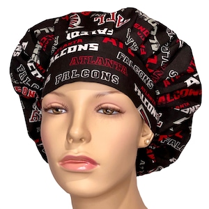 May include: A black and red Atlanta Falcons scrub hat. The hat features the team name and logo in white and red lettering. The hat is designed with a gathered crown and a wide band.